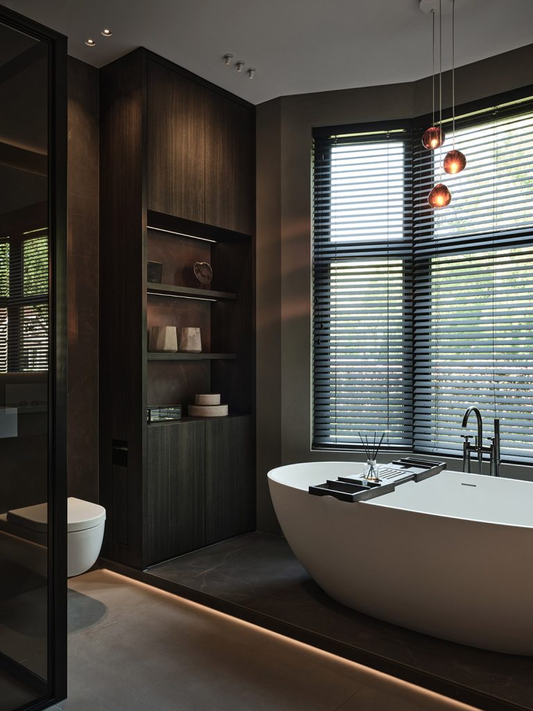 Luxe badkamer met vrijstaand ligbad, maatwerk badkamerkast, Decolegno houtafwerking en geïntegreerde verlichting in een woonboerderij in Roden, ontworpen door DUIN Interior en gerealiseerd door A&F Interieurbouw.