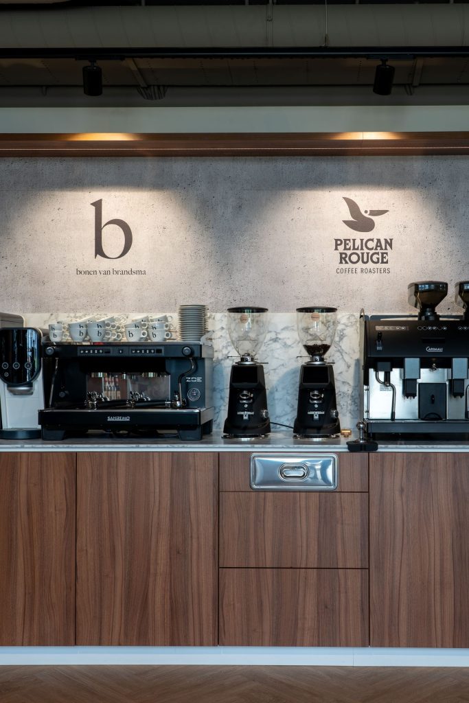 Maatwerk werkblad en kastenwand met koffieapparatuur bij Brandsma Koffie in Bolsward, gerealiseerd door A&F Interieurbouw.