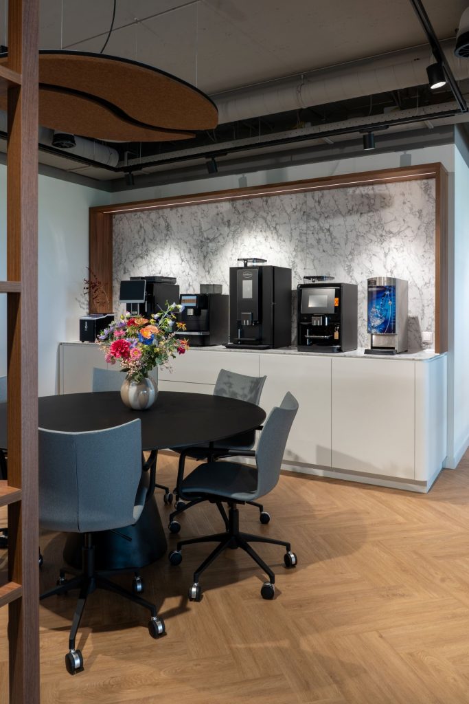 Maatwerk vergaderruimte en koffiecorner met marmerlook achterwand bij Brandsma Koffie in Bolsward, gerealiseerd door A&F Interieurbouw.