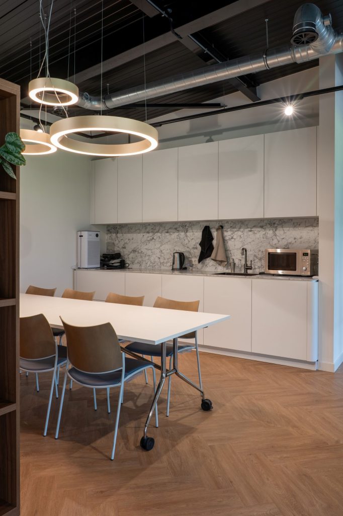 Maatwerk pantry en vergaderruimte met kastenwand en marmerlook achterwand bij Brandsma Koffie in Bolsward, gerealiseerd door A&F Interieurbouw.